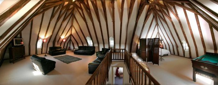 The relax room with its slightly sloping ceilings under an inverted hull shaped roofing framework would make some wonderful bedrooms